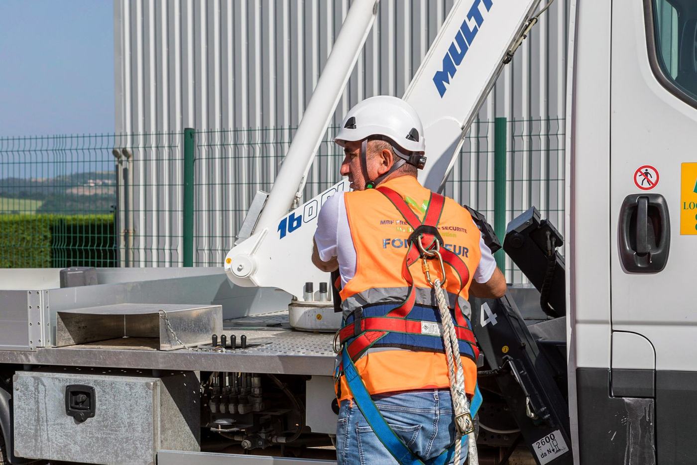 Opérateur équipé d'un harnais antichute sur une nacelle sur porteur Multitel