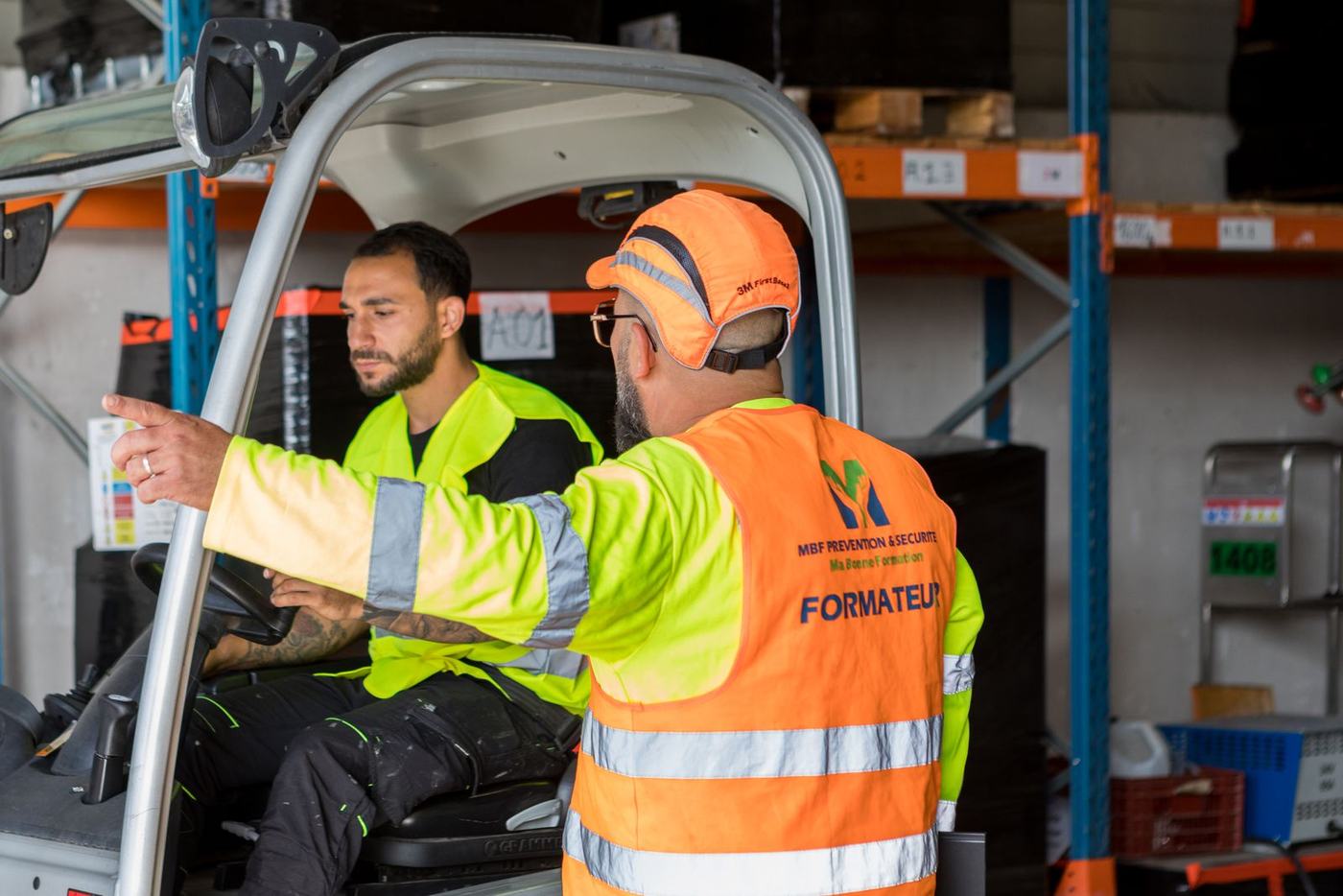 Formateur CACES® R489 donnant les consignes à un stagiaire installé sur le chariot