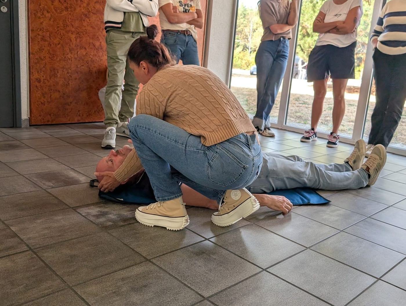 Stagiaire SST prenant en charge une victime au sol lors d'une mise en situation