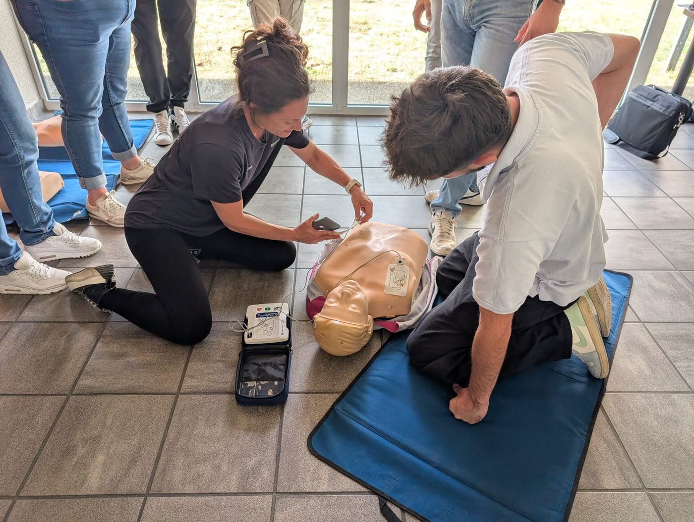 Mise en œuvre du défibrillateur (DAE) et massage cardiaque sur mannequin, formation SST