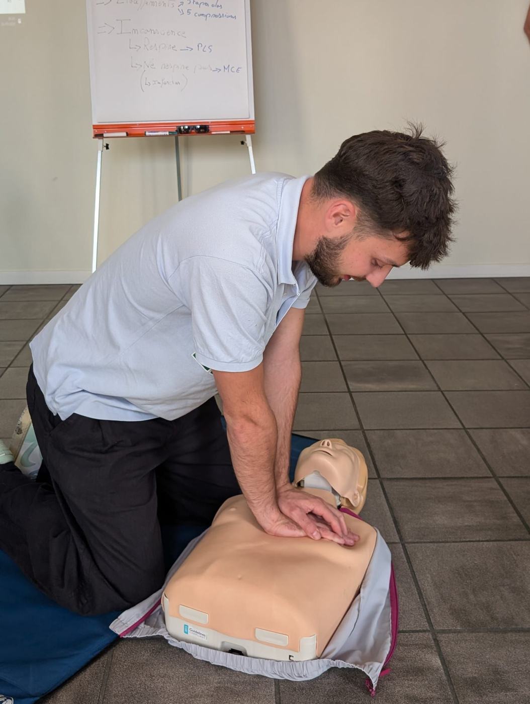 Stagiaire pratiquant la réanimation cardio-pulmonaire sur mannequin, formation SST